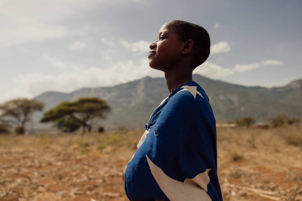 Sarah looks ahead, determined to complete her education, the mountains of Tanzania behind her.