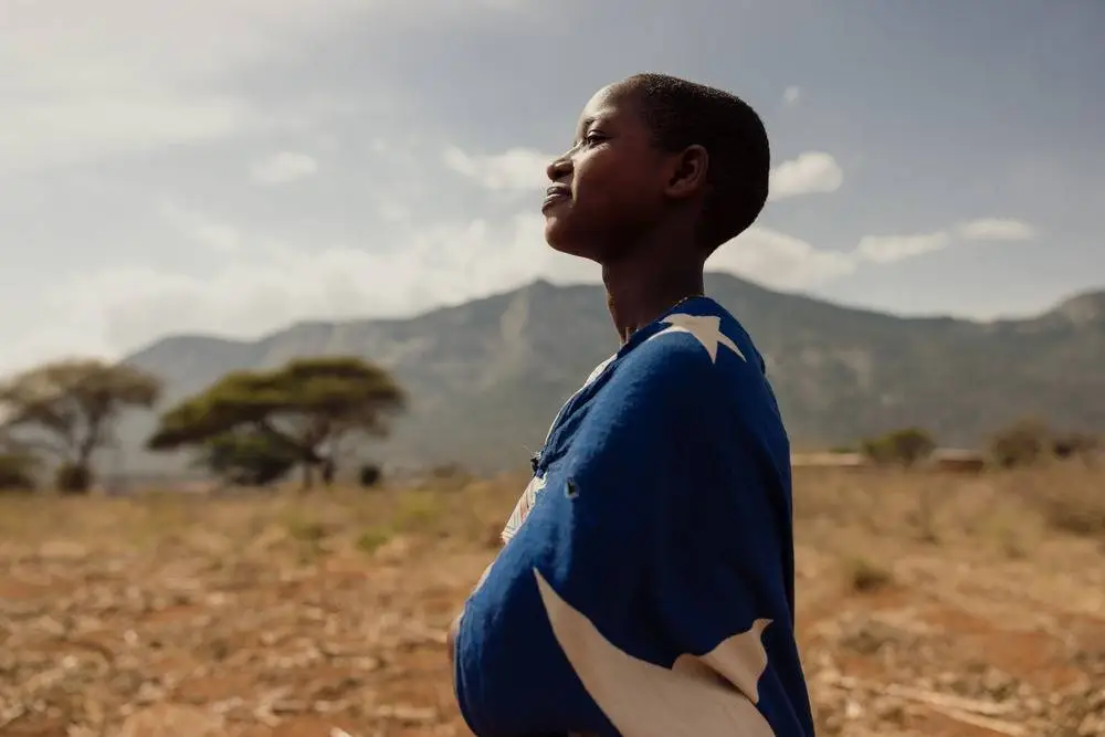 Sarah looks ahead, determined to complete her education, the mountains of Tanzania.