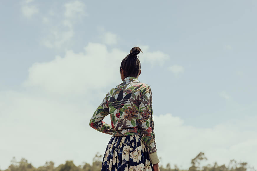 A survivor of gender-based violence stands looking over the horizon with fresh confidence as she focuses on her future.